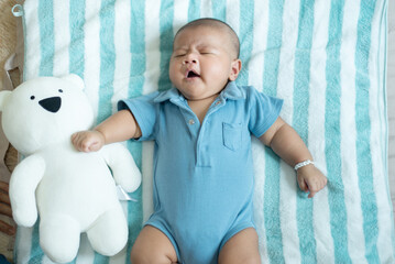 Lazy adorable asian baby boy yawning and relax on bed,Newborn child