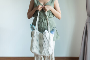 Asian woman holding reusable water bottle and white rag bag,Healthy green,Zero waste,Environmental friendly
