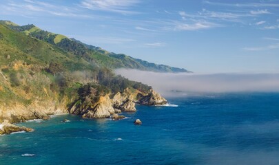 Fototapeta premium Rocks and wild foggy ocean coastline in Big Sur. San Simeon, California, United States of America.