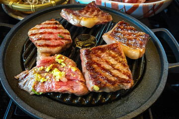 Large pieces of marbled wagyu beef grilled on a pan are a high quality and famous premium beef from...
