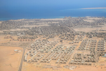 Aerial View of Coastal Town by Red Sea. Overlooking of coastal city with clear blue waters and...