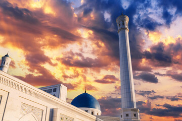 high white minaret and blue dome of modern Minor Mosque in Tashkent in Uzbekistan on background of...