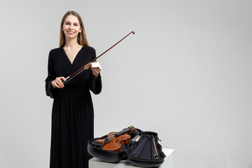 Elegant woman playing violin wearing black attire