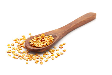 Front view of a wooden spoon filled with Organic Green Chilli (Capsicum annuum) seeds. Isolated on a white background.
