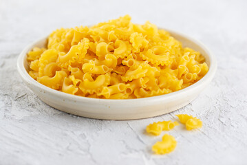 Dry pasta Creste Di Gallo in a white plate.