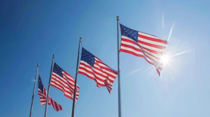 Four American flags waving in front of the sun