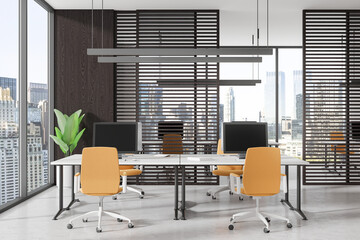 Modern coworking interior with pc monitors on tables, panoramic window