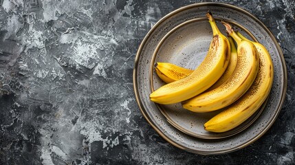   A bunch of bananas on a gray countertop, placed on a plate beside a knife and fork - Powered by Adobe