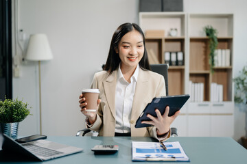 Confident business expert attractive smiling young woman typing laptop and holding digital tablet