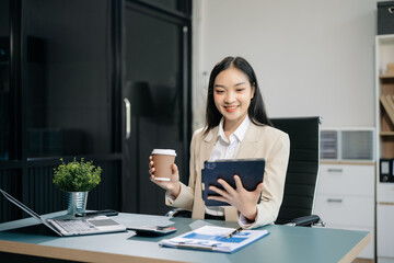 Confident business expert attractive smiling young woman typing laptop and holding digital tablet