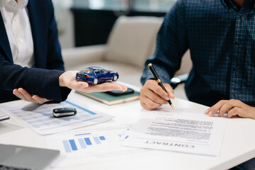 Asian people car salesman or sales manager offers to sell a car and explains of signing a car contract