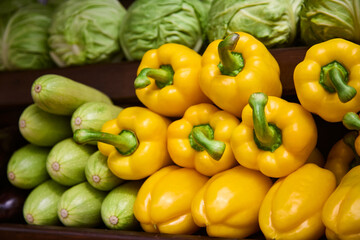 Yellow bell pepper, cabbage and zucchini on market. Close up.