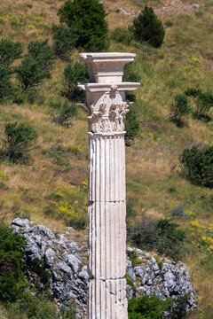 Honorary column at Upper Agora in ancient city of Sagalassos. Corinthian capital, intricate green hill backdrop. Cover page. Aglasun, Budur, Turkey (Turkiye)