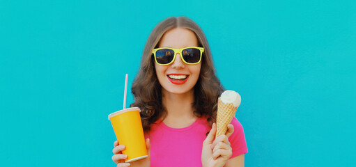 Summer portrait of happy smiling young woman eating ice cream and holding cup of fresh juice