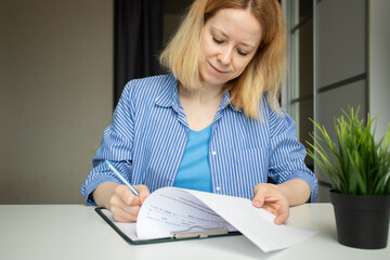 Documentation, a woman writes on forms, filling out an agreement, signing a contract