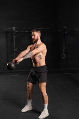 Man performing kettlebell swings, holding kettlebell in both hands. Routine workout for physical and mental health.