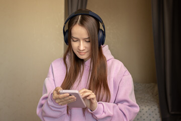 Teenager listens to music from her phone and dances at home, teen swaying to the melody, joyful movement, indoor happiness,getting lost in the song, carefree dancing, indoor joy.