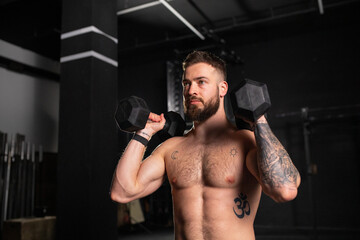 Portrait of man holding dumbells in both hands. Routine workout for physical and mental health.