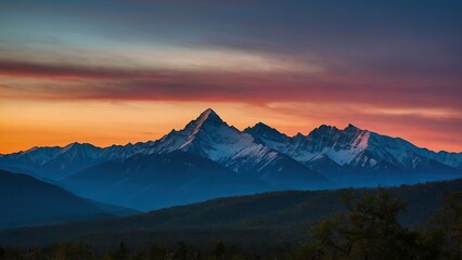Fototapeta premium Snow capped mountain peak at sunset with vibrant skies
