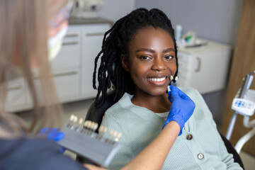 Smiling dark-skinned woman at the dentists looking contented