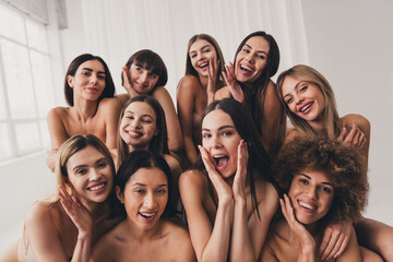 Group photo of ten girlfriends in beige bras laughing together touch imperfections at studio white color background