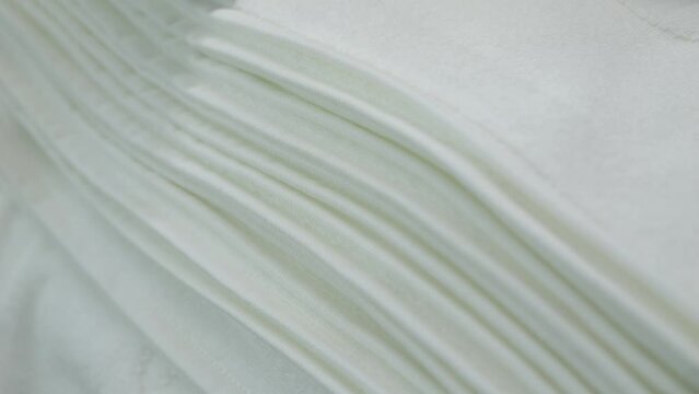 Stack of soft snow-white towels close-up, hotel. Stack of white fabrics close-up