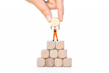 Miniature worker on stack of wooden cube isolate on white background, business goal concept