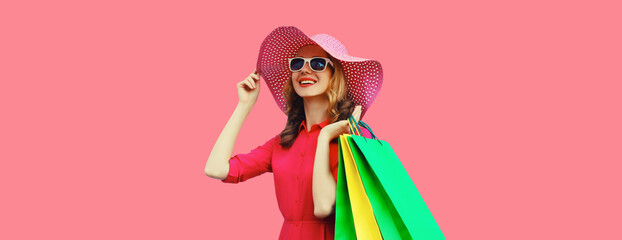 Beautiful happy smiling young woman model posing with shopping bags in summer hat