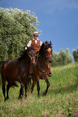 Beautiful Italian woman, riding her Maremmano horse and handling her yearling