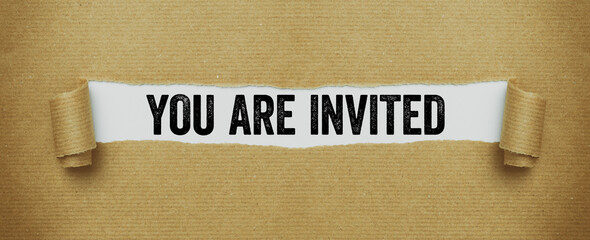 Torn paper revealing the words You are invited