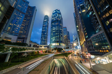 Skyscraper buildings and traffic on road with blurred cars light trails at night, Hong Kong, China