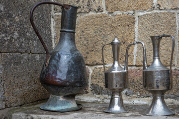 Antique metal vessels for water and wine. A copper jug in an ancient fortress. Antique handmade...