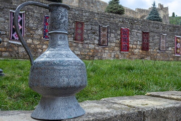 Antique metal vessels for water and wine. A copper jug in an ancient fortress. Antique handmade...