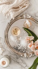 Top-view shot of a vintage silver tray with a luxurious bath setup: a glass of champagne, delicate bath salts, a single orchid