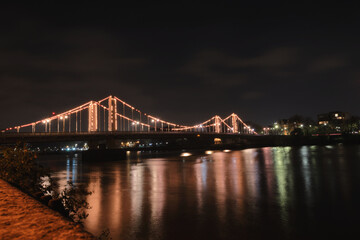 Night view of Chelsea Bridge, London illuminated in the dark