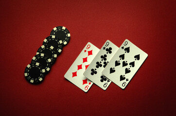 Big luck in a card game of poker with a winning combination of three of a kind or set. Playing cards and chips are laid out in a club on a red table