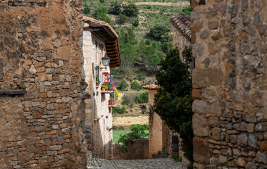 Old stone walls and cobbled narrow cozy street of a medieval village in Provence, France. View of...