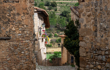 Fototapeta premium Old stone walls and cobbled narrow cozy street of a medieval village in Provence, France. View of traditional old stone houses.