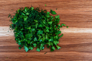 Fresh green dill and cilantro on a wooden cutting board. Food and cooking concepts