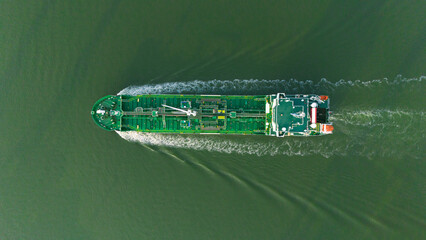 Aerial top view over an international natural gas tanker at an industrial import and export port preparing to load containers with a large container ship. Global shipping and logistics business.