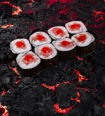 Sushi rolls on fiery lava texture background