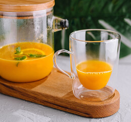 Freshly blended orange smoothie in glass and pitcher