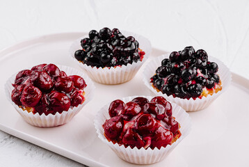 Assorted berry tartlets on white plate
