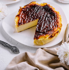 Obraz premium Traditional basque burnt san sebastian cheesecake slice on elegant table setting