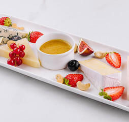 Gourmet cheese platter with fresh fruits and dips