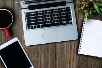 Laptop and tablet are on top of office desk table with cup of latte coffee and calculator in office, top view. Online Shopping Concepts.