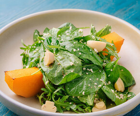 Fresh spinach and pumpkin salad on ceramic plate