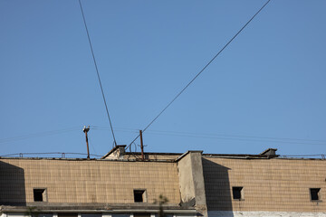 Electrical wires between buildings against a background of blue sky with clouds