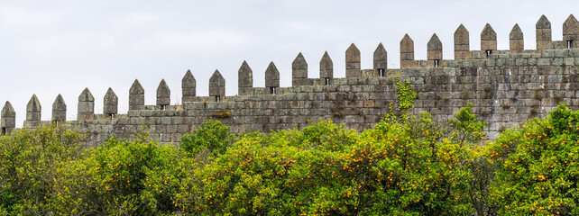 The Fernandinha wall. Medieval wall with trees and cloudy sky. Porto, Portugal.