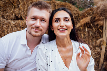 Obraz premium Portrait of young smiling couple in love against backdrop of garden or nature